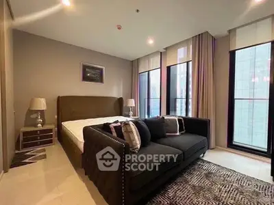 Luxurious bedroom with modern decor and large windows in a high-rise apartment.