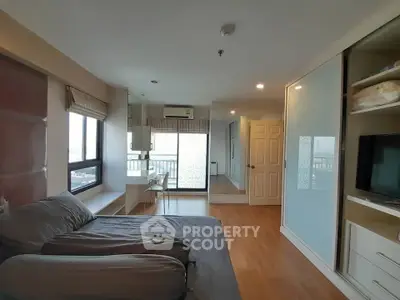 Spacious bedroom with modern decor and large windows offering natural light and city views.