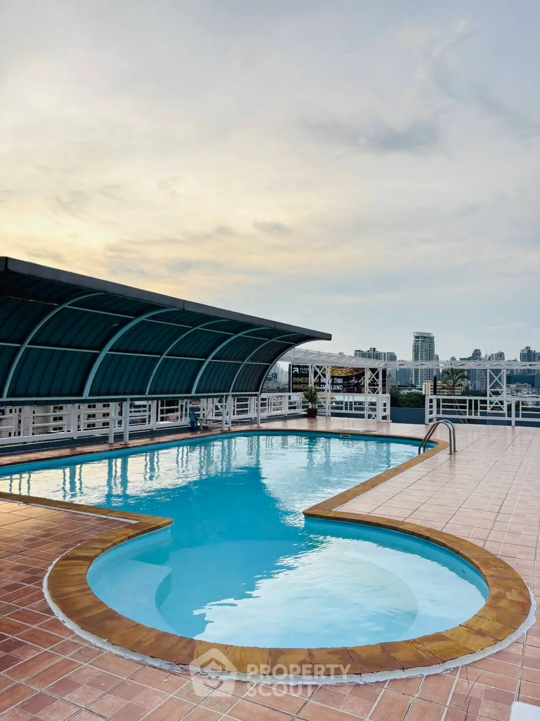 Stunning rooftop pool with city skyline views at sunset, perfect for relaxation and leisure.