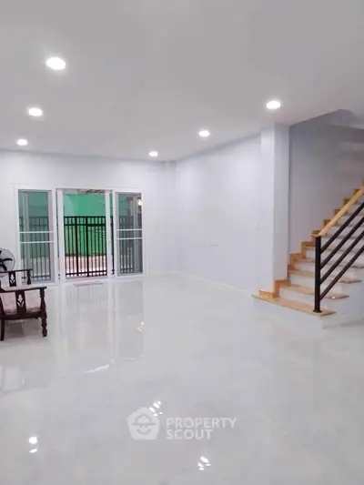 Spacious modern living room with sleek staircase and bright lighting