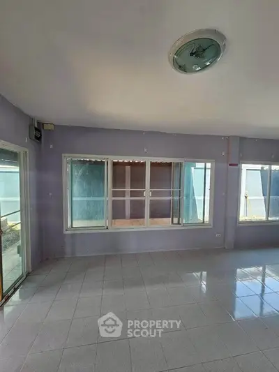 Spacious empty room with large windows and tiled floor, perfect for customization.