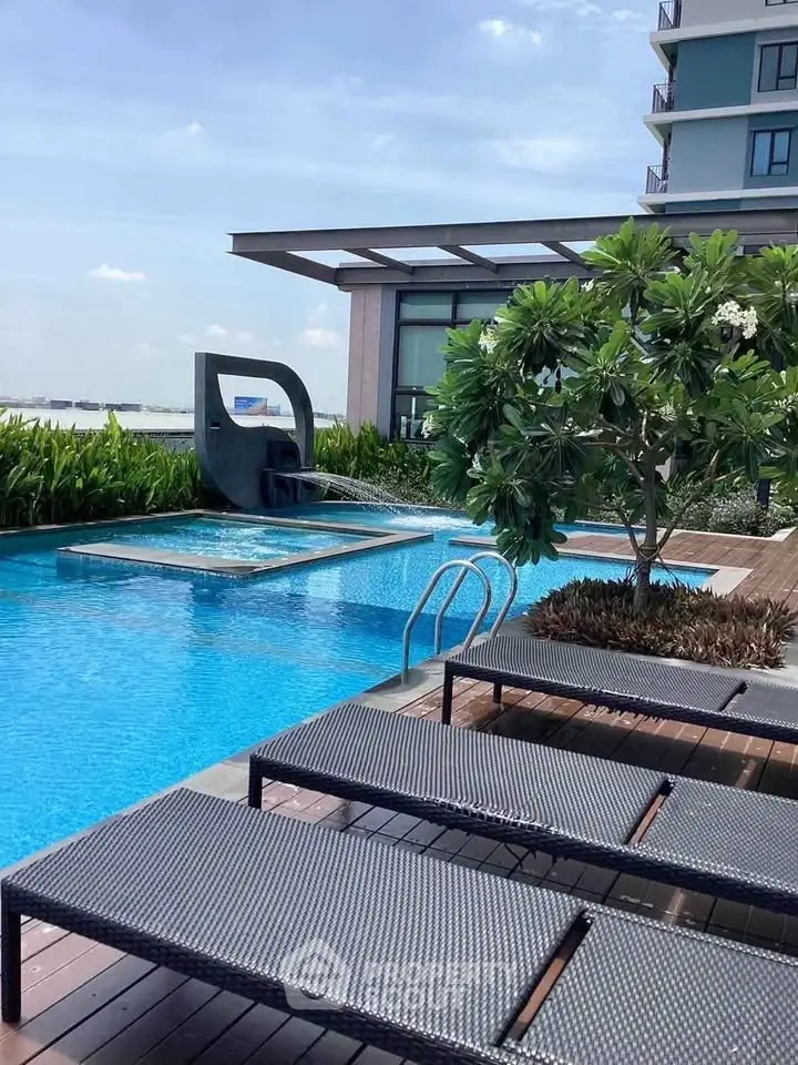 Luxurious poolside area with modern loungers and scenic views in upscale residential complex.