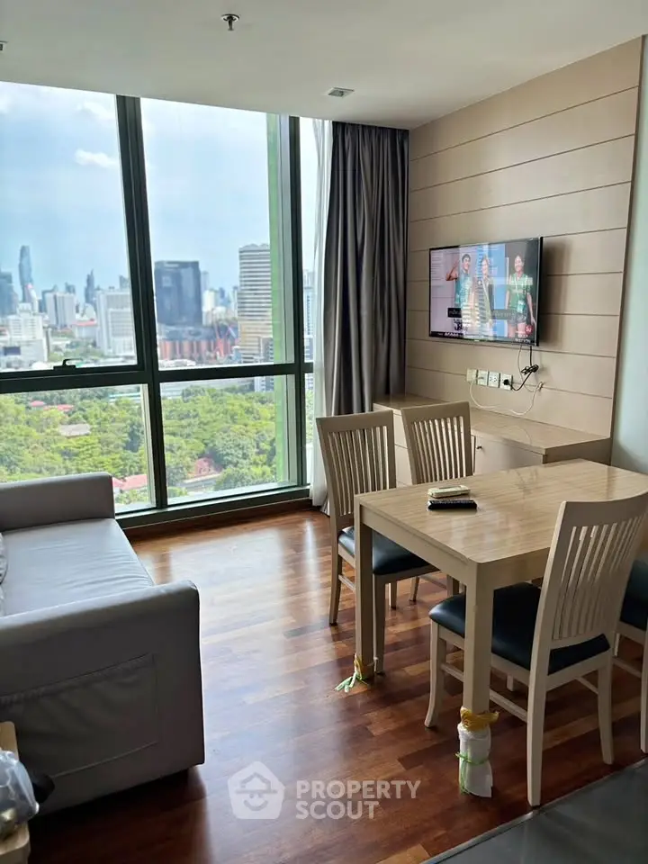 Modern living room with city view, featuring sleek furniture and large windows for natural light.