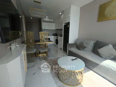 Luxurious modern living room with elegant decor and open kitchen layout, featuring stylish furniture and appliances.