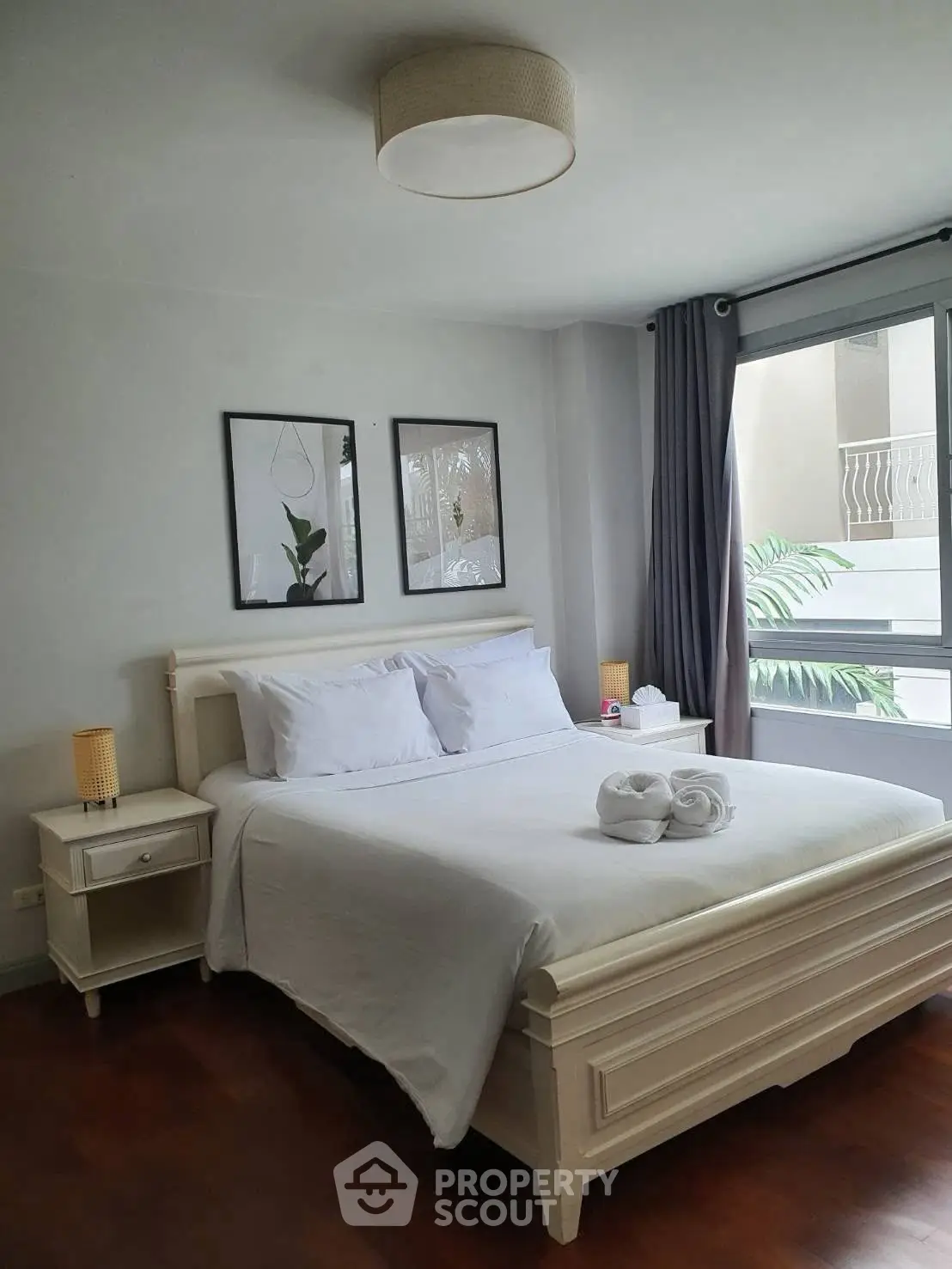 Elegant bedroom with modern decor and large window offering natural light.