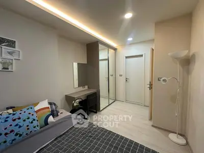 Modern bedroom with stylish decor and mirrored wardrobe in cozy apartment.