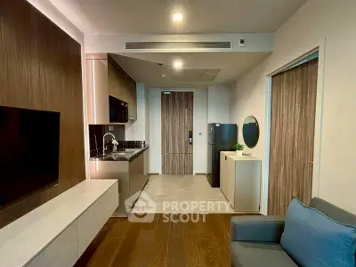 Modern apartment interior with sleek kitchen and cozy living area, featuring wood accents and contemporary design.