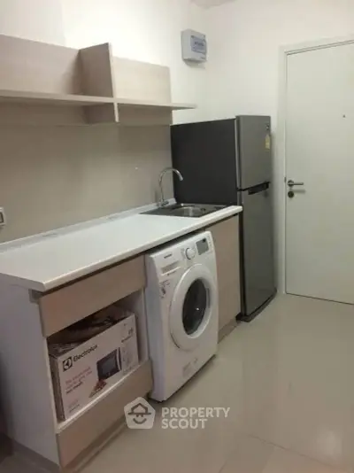 Modern kitchen with washing machine and fridge in compact layout