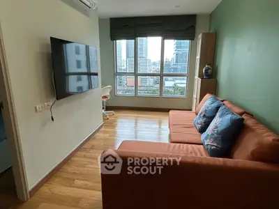Modern living room with city view, featuring a cozy sofa and wall-mounted TV.