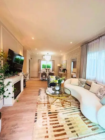 Luxurious living room with elegant decor and spacious layout, featuring a stylish curved sofa and modern fireplace.