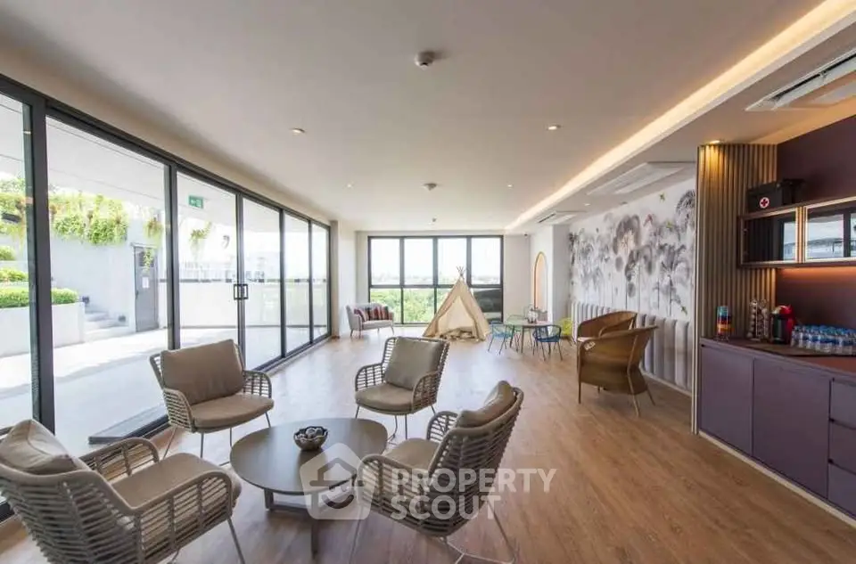 Spacious modern living room with large windows and outdoor access, featuring stylish seating and elegant decor.
