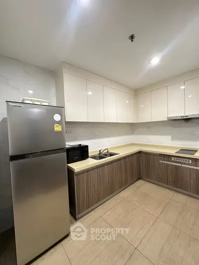 Modern kitchen with sleek cabinetry and stainless steel appliances in a stylish apartment.