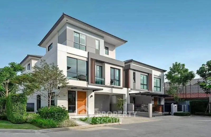 Modern two-story house with sleek design and lush landscaping