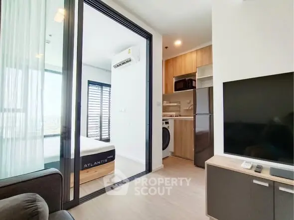 Modern apartment interior with open layout, featuring a cozy living area, compact kitchen, and bright bedroom.