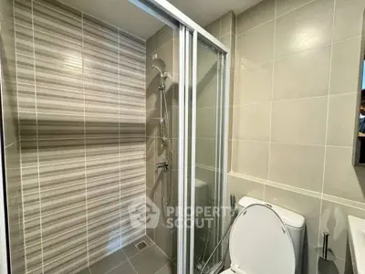 Modern bathroom with sleek shower and neutral tiles in a contemporary apartment.