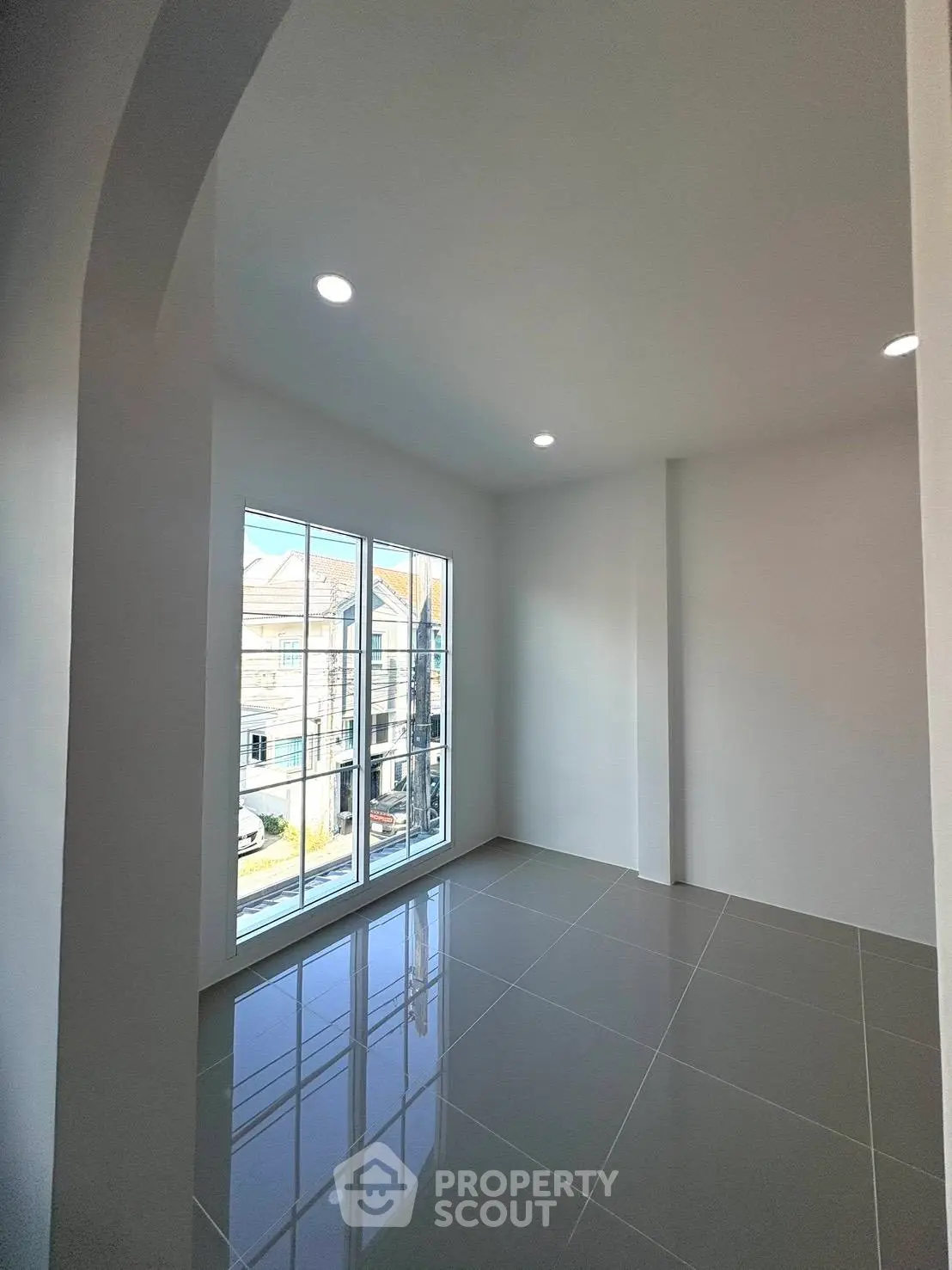 Bright empty room with large windows and glossy tiled floor, perfect for customization.