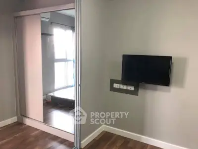 Modern apartment interior with wall-mounted TV and mirrored closet doors