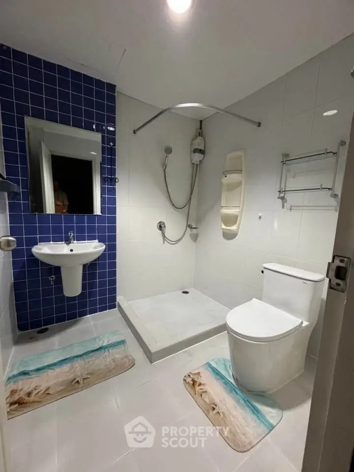 Modern bathroom with sleek fixtures and stylish blue tile accent wall.