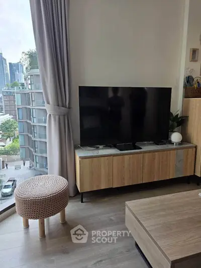 Modern living room with large TV and city view from window