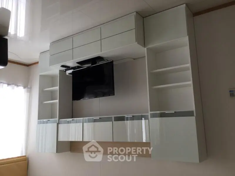 Modern living room with sleek wall-mounted TV and stylish storage cabinets