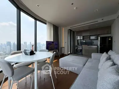Modern living room with panoramic city view, sleek furniture, and open kitchen layout.