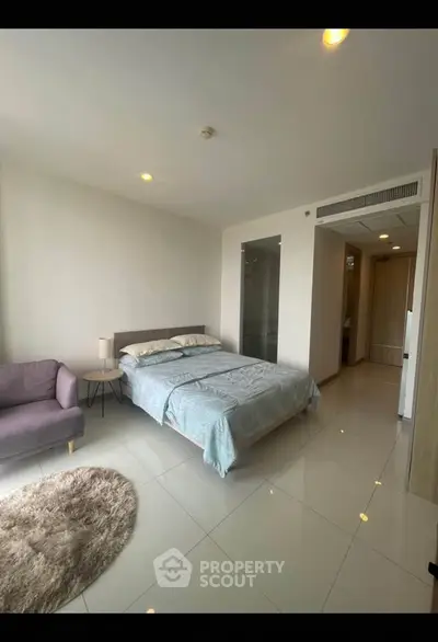 Spacious modern bedroom with cozy decor and natural light
