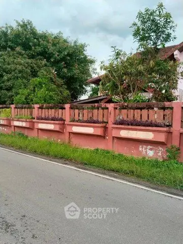 Charming suburban house with lush greenery and rustic fence