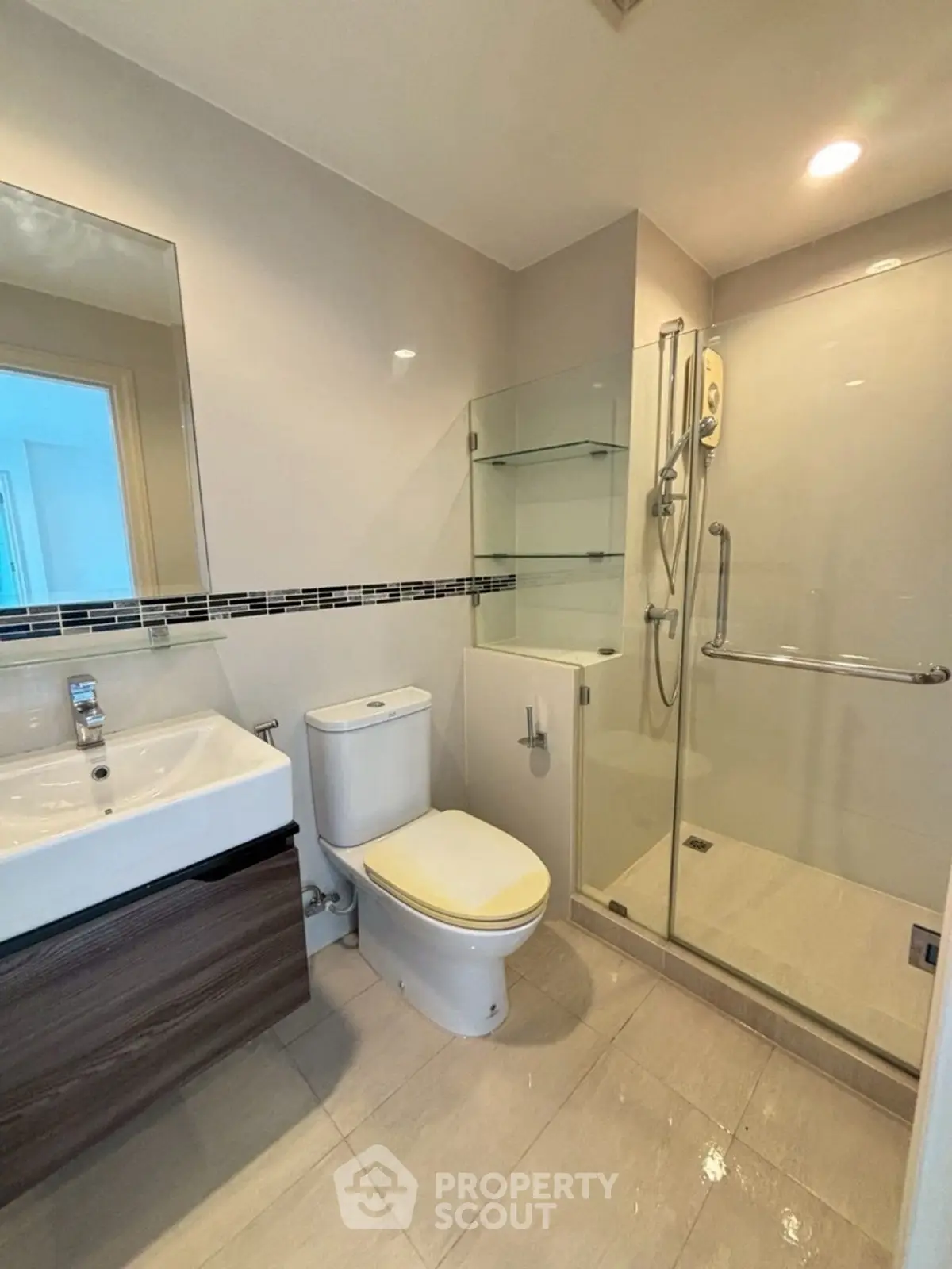 Modern bathroom with glass shower and sleek vanity in a contemporary home.