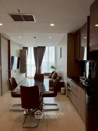 Modern living room with dining area and sleek kitchen in open layout apartment.