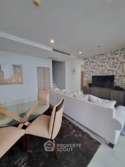 Spacious living room with modern decor and elegant dining area