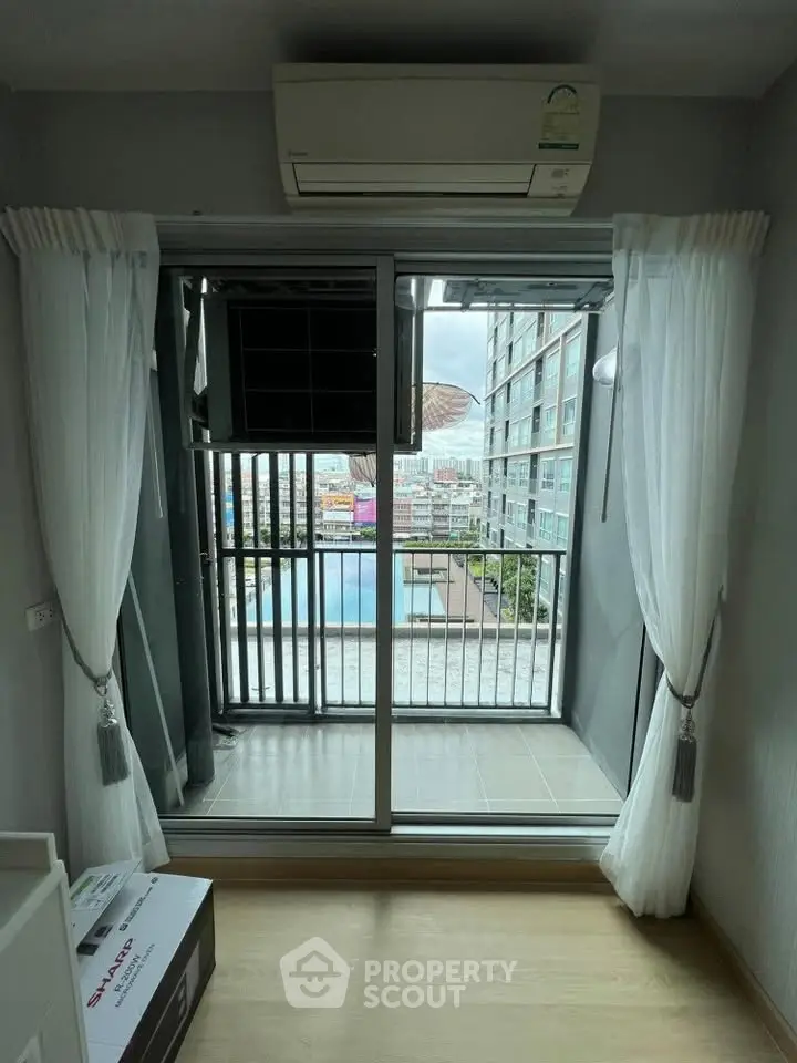 Modern apartment with balcony overlooking pool and cityscape, featuring air conditioning and elegant curtains.