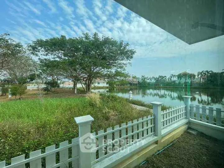 Charming lakeside view from a property with lush greenery and serene surroundings.