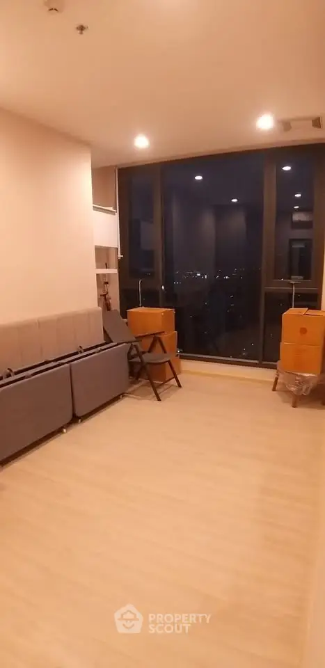 Spacious living room with large windows offering stunning city views, perfect for modern urban living.