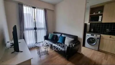 Cozy living room with modern sofa, TV, and washing machine in stylish apartment.