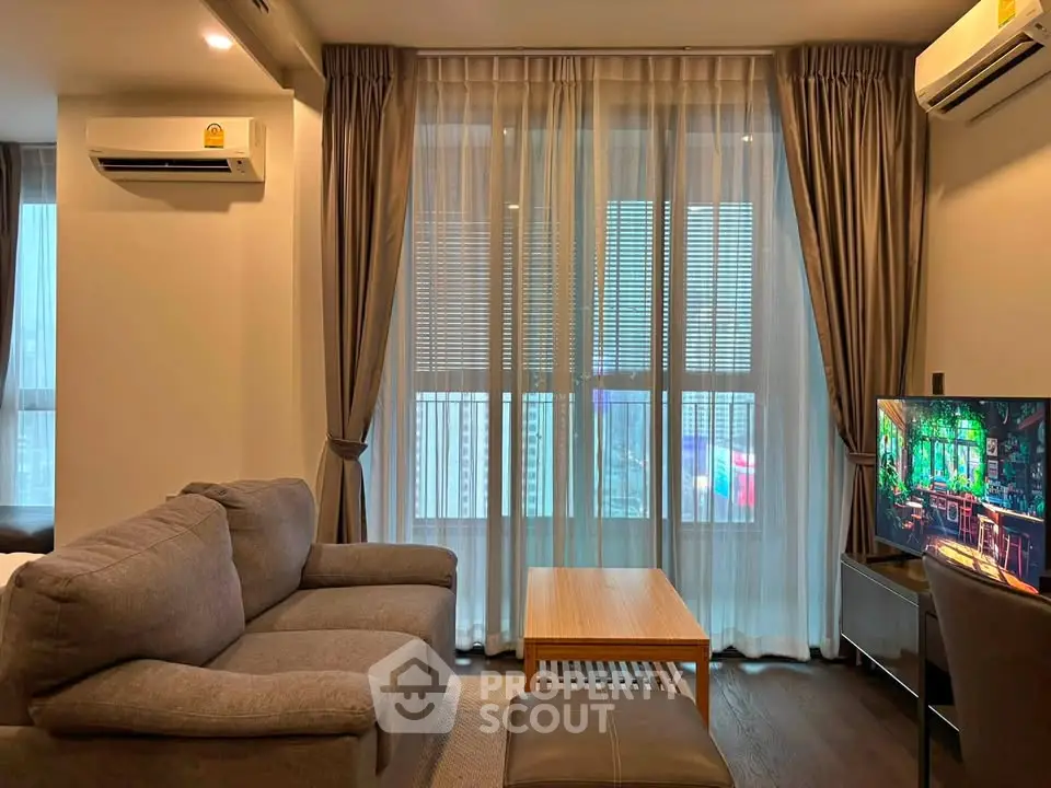 Modern living room with cozy sofa, large window, and air conditioning unit in a stylish apartment.