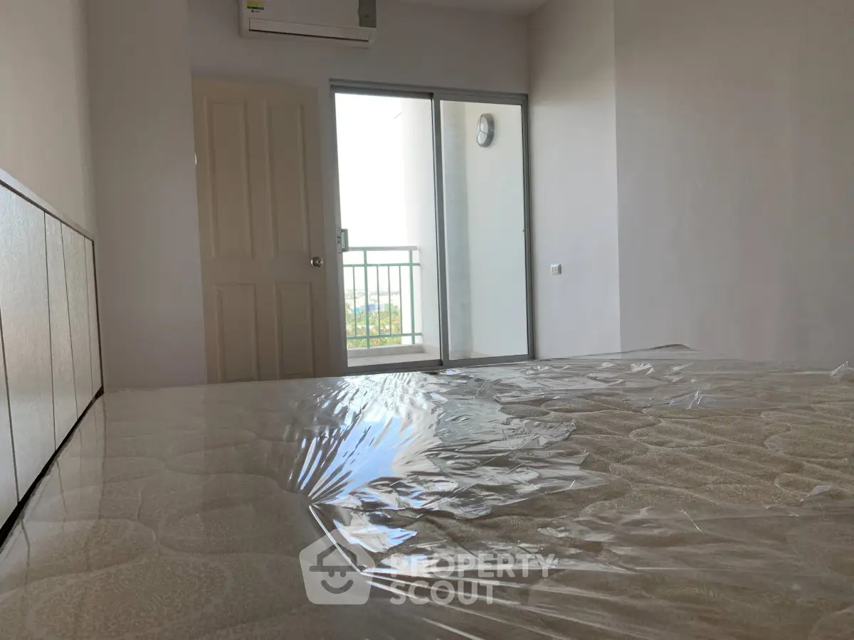 Spacious bedroom with balcony access and natural light, ideal for relaxation and comfort.