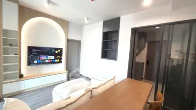 Modern living room with sleek design, featuring a wall-mounted TV and stylish furniture.