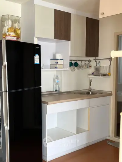 Modern kitchen with sleek cabinetry and stainless steel fridge