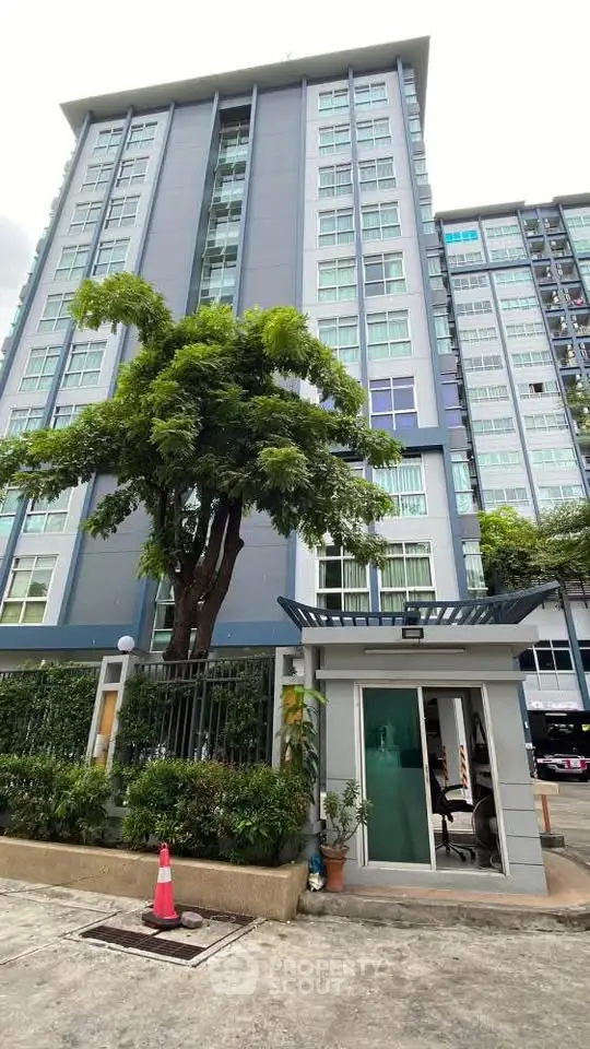 Modern high-rise building with lush greenery and secure entrance