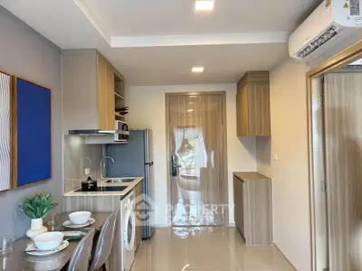 Modern kitchen with washing machine and sleek cabinetry in compact apartment