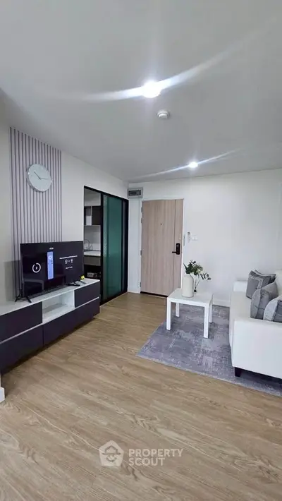 Modern living room with sleek furniture and stylish decor, featuring a cozy sofa and entertainment unit.