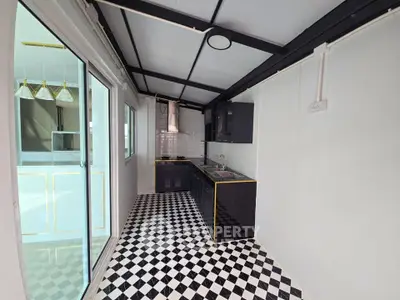 Stylish modern kitchen with black cabinets and checkered floor tiles, featuring open layout and sleek design.
