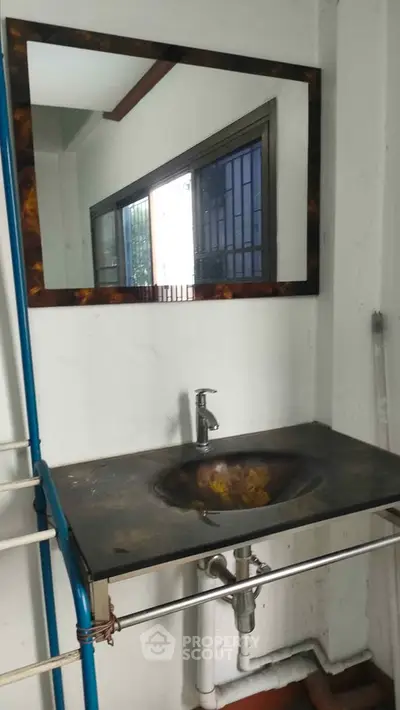 Compact bathroom sink with mirror in a minimalist setting