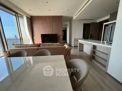 Luxurious open-plan living room with modern kitchen and stunning city view.