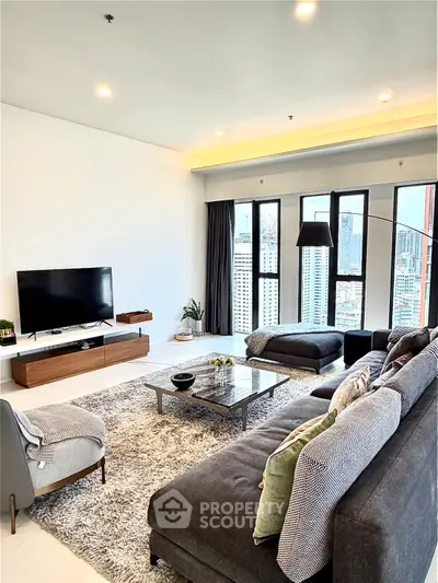 Spacious modern living room with city view, featuring stylish furniture and large windows.