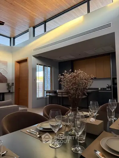 Modern open-plan living and dining area with elegant decor and high ceilings.