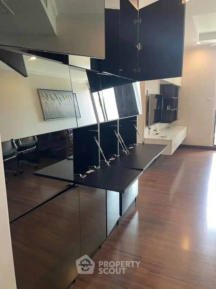 Modern office space with sleek black cabinetry and hardwood floors, ideal for a professional setting.