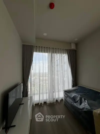 Modern living room with large window and sleek furnishings