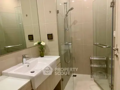 Modern bathroom with glass shower and sleek vanity in contemporary apartment