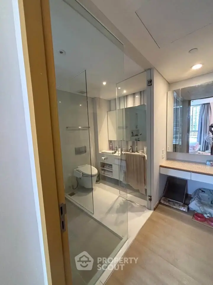 Modern bathroom with glass enclosure and sleek fixtures in a stylish apartment.